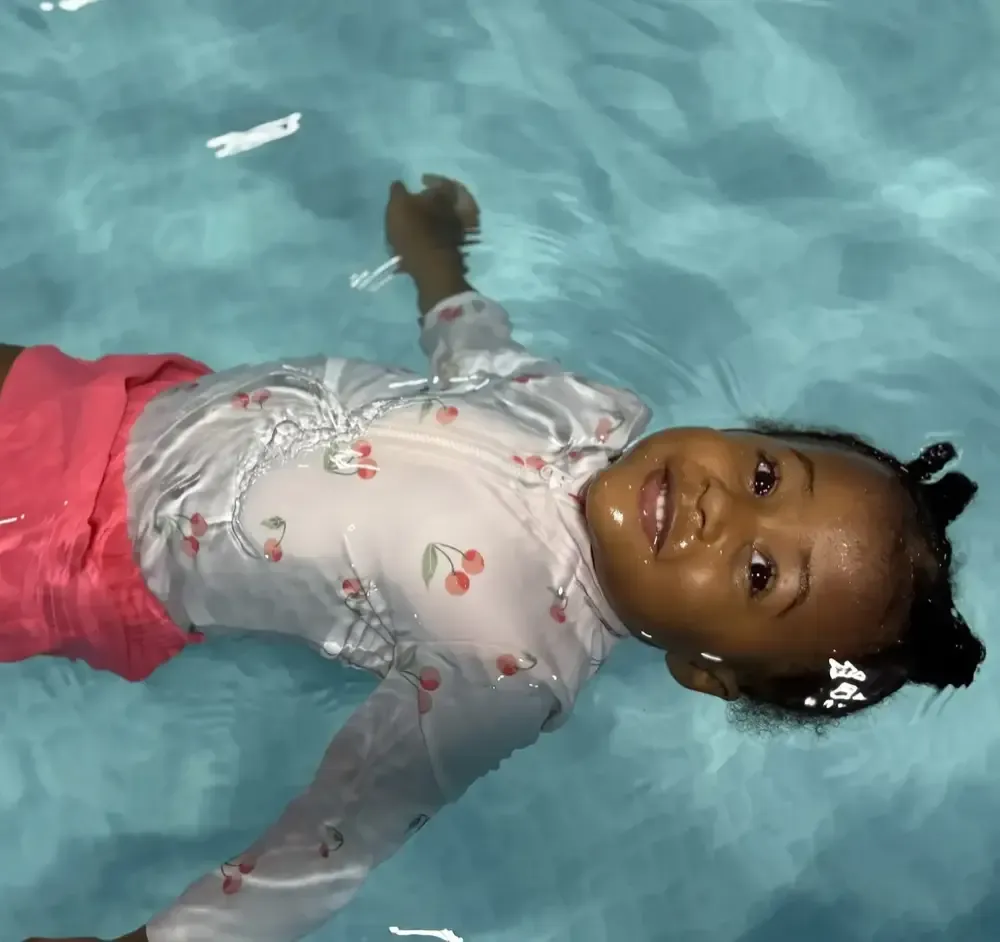 An infant floating calmly on her back, unassisted